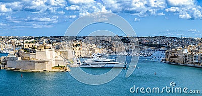 Luxury yachts and boats in front of ancient Valletta waterfront buildings and harbour. Valletta, Malta Editorial Stock Photo
