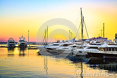 Luxury yachts docked in sea port at colorful sunset. Stock Photo