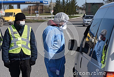 Lviv, Ukraine - April 10, 2020: Medical worker checks temperature of a driver on a checkpoint on the entrance to Lviv region. Editorial Stock Photo