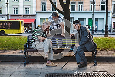 Lviv, Ukraine - August 3, 2019 - seniors playing chess at city bench park Editorial Stock Photo