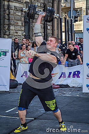 LVIV, UKRAINE - AUGUST 2015: Strong athlete athlete raises heavy weight on Strongmen games Editorial Stock Photo