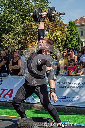 LVIV, UKRAINE - AUGUST 2015: Strong athlete athlete raises heavy weight on Strongmen games Editorial Stock Photo