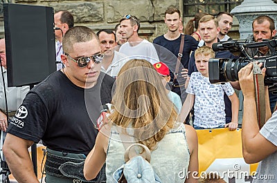 LVIV, UKRAINE - AUGUST 2015: Strongman`s strong athlete is taken by a TV interviewer Editorial Stock Photo