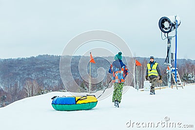 LVIV, UKRAINE - January 7, 2019: children sliding snow tube down by snowed hill Editorial Stock Photo