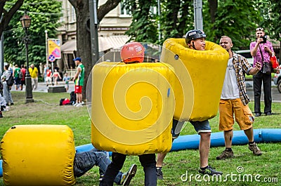 LVIV, UKRAINE - JUNE 2016: Young guys fighting in a comic battle of inflatable balls and helmets Editorial Stock Photo