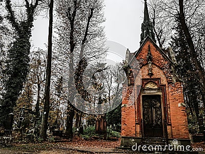 Lviv / Ukraine - November 2019: Old crypt at Lychakiv cemetery in late autumn. Orange brick, dark colors, no people around. Stock Photo