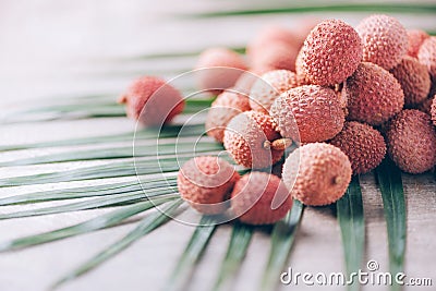 Lychee fruits with palm leaves on rattan background. Copy space. Exotic litchi, lichee fruits. Tropical food concept Stock Photo
