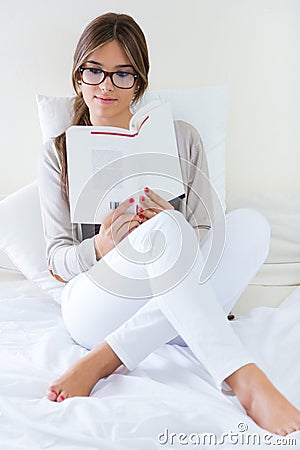 Lying beautiful woman reading book at home. Stock Photo