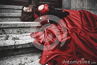 Lying and bleeding woman in Victorian dress Stock Photo