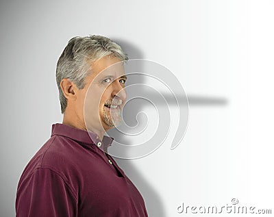 Lying dishonest man with his growing long liar Pinocchio nose showing in his shadow Stock Photo
