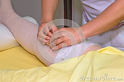 Lymphedema management: Wrapping leg using multilayer bandages to control Lymphedema. Part of complete decongestive therapy cdt a Stock Photo