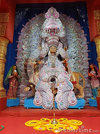 Maa Jagadhatri , one from of Durga ,in a well decorated pandal ,with a flower decoration and a holy lamp infront her. Stock Photo