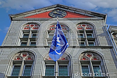 Low angle view on facade of old dutch visitor center building, clock, flag of VVV tourist information against blue sky Editorial Stock Photo