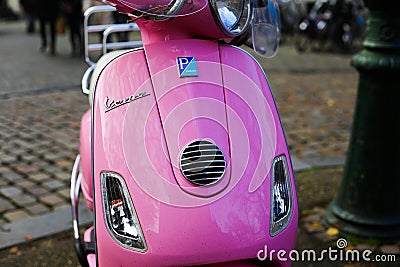 Front view on retro pink Vespa scooter parked on city square Editorial Stock Photo
