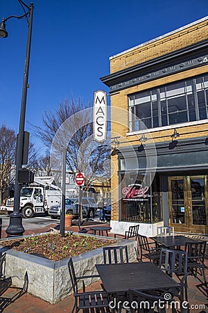 Mac’s Chophouse with a red brick sidewalk lined with shops, restaurants and bars with tables and chairs on the sidewalk Editorial Stock Photo