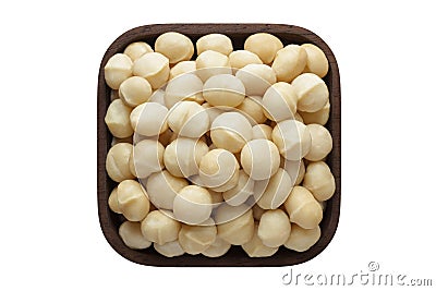 Macadamia nuts peeled in square bowl isolated on white background. organic food, top view Stock Photo