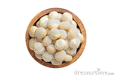 Macadamia nuts peeled in wooden bowl isolated on white background. Vegan food, top view Stock Photo