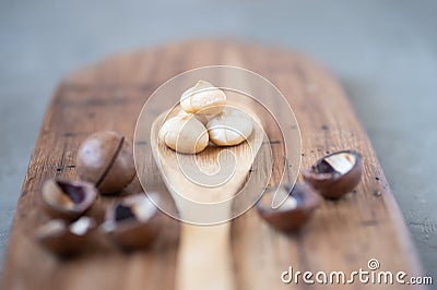 Macadamia peeled in spoon wooden board nutshell Stock Photo