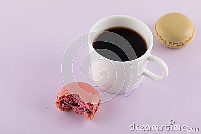 Macaron with bite mark and Coffee,Pastel colors, purple background Stock Photo