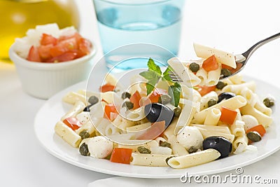 Macaroni mozzarella olives capers tomatoes salad Stock Photo