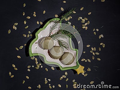 Macaroni pistachio on a decorative plate in the form of a Christmas tree, lying diagonally Stock Photo