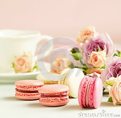 Macaroons in pastel colors with flowers on a pale pink background.Holiday background Stock Photo