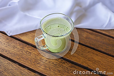 Macha Latte glass on wooden panels table Stock Photo