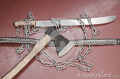 Machete, chain, ax and belt with metal inserts-an attribute of a metal player. Stock Photo