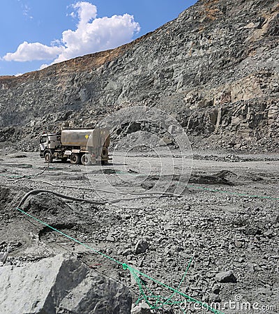 Machine pumps plastic explosives into holes. Mining in quarry. Stock Photo