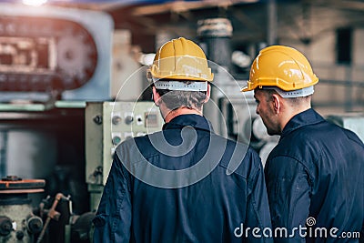Machine service talking together teamwork working in factory back view Stock Photo