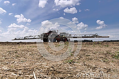 Machine for spraying pesticides and herbicides in the field against blue sky. Heavy machinery for agriculture Stock Photo