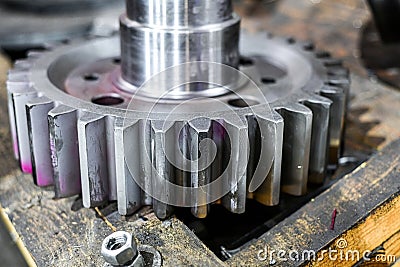 The machined toothed gear on the cnc machine lies on the board in the workshop Stock Photo