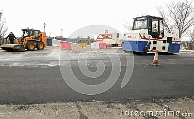 Machines performing asphalting and paving work on a city road. Editorial Stock Photo