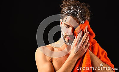 Macho attractive nude guy black background. Man bearded tousled hair covered with foam or soap suds. Wash off foam with Stock Photo