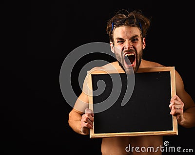 Macho attractive nude guy hold blackboard. Man with beard and tousled hair black background. Man muscular torso Stock Photo