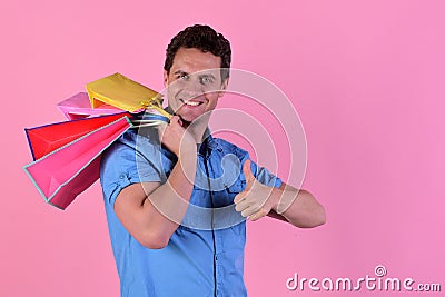 Macho in blue shirt with packages in hand. Stock Photo