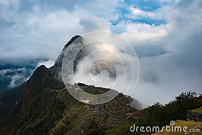 Machu Picchu illuminated by sunlight coming out from the opening clouds. The Inca`s city is the most visited travel destination i Stock Photo