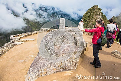 Tourist in front of Intihuatana stone, sacred valley, Cusco region, Peru Editorial Stock Photo