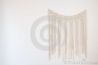 A macrame hanging on white cement wall for home and wedding decoration with copy space Stock Photo