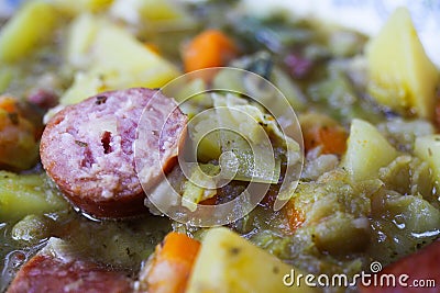 Macro close up of german hearty pea stew with potatoes, leek, carrots and smoked sausages - Germany Stock Photo