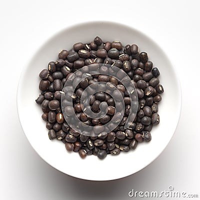 Macro Close-up of Organic Black Gram Vigna mungo or whole black urad inside a ceramic white bowl. Stock Photo