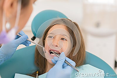 Macro close up of young child with open mouth at dentist. Teeth checkup at dentist's office. Dentist examining girls teeth in the Stock Photo