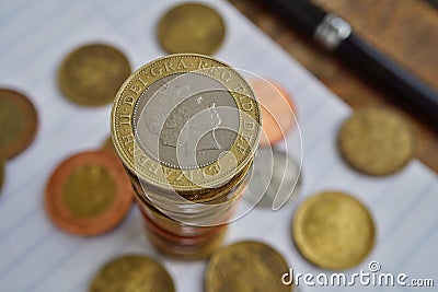 Macro detail of a silver and golden coin in a value of two British Pounds Sterling on the top of coins` pile Editorial Stock Photo