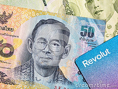 Macro detail with a 50 Thai Baht banknote and a revolut debit or credit card. The baht is the official currency of Thailand Editorial Stock Photo