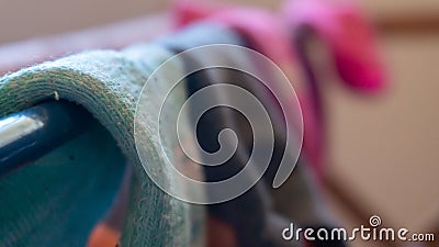 Macro detail of woven ankle sock close up, drying on a laundry rack, with blurred background of other socks, mismatched. Depicting Stock Photo