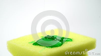 Macro fine eccellente su metraggio della spugna gialla per il piatto e del detersivo di versamento nella forma di gel verde stock footage Macro fine eccellente su metraggio della spugna gialla per il piatto e del detersivo di versamento nella forma di gel verde stock footage