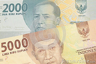 A grey two thousand Indonesian rupiah bank note paired with a orange five thousand Indonesian rupiah note. Stock Photo