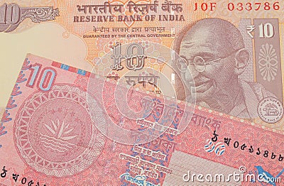 A orange ten rupee bill from India paired with a red ten taka bank note from Bangladesh. Stock Photo