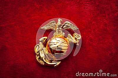 Macro image of the US Marine Corps emblem on red velvet as background and a grungy aesthetic. Semper fidelis or Semper Fi is Latin Stock Photo