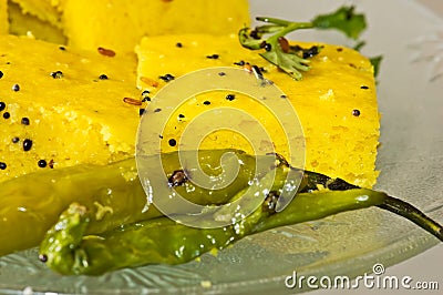 Macro of Indian Snacks Dhokla with fried chillies Stock Photo
